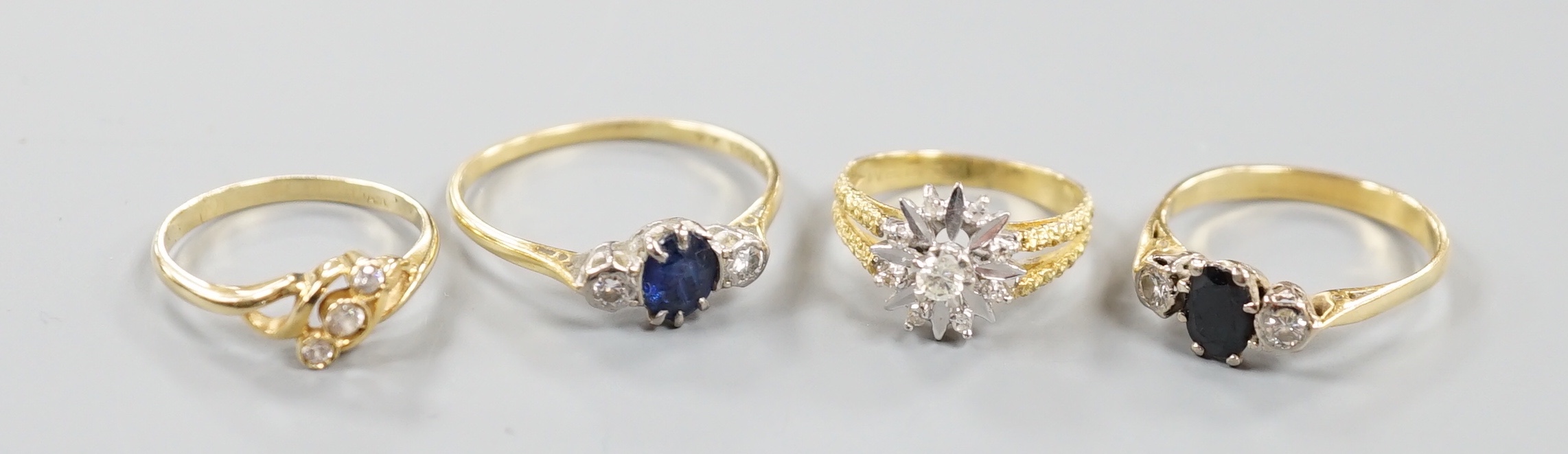 Two 18ct and gem set dress rings, including sapphire and diamond, gross 5.9 grams, a 585 crossover ring, gross 1.8 grams and a yellow metal, sapphire and diamond set ring, gross 3.1 grams.